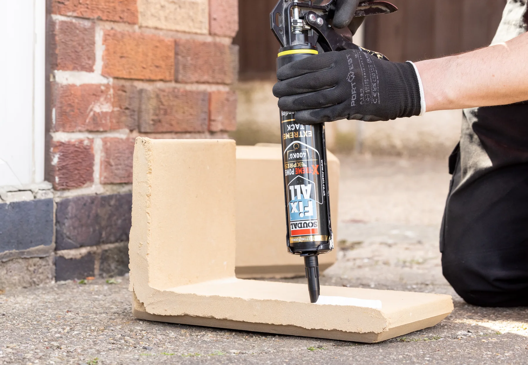 Applying Soudal Fix All construction adhesive to a masonry unit