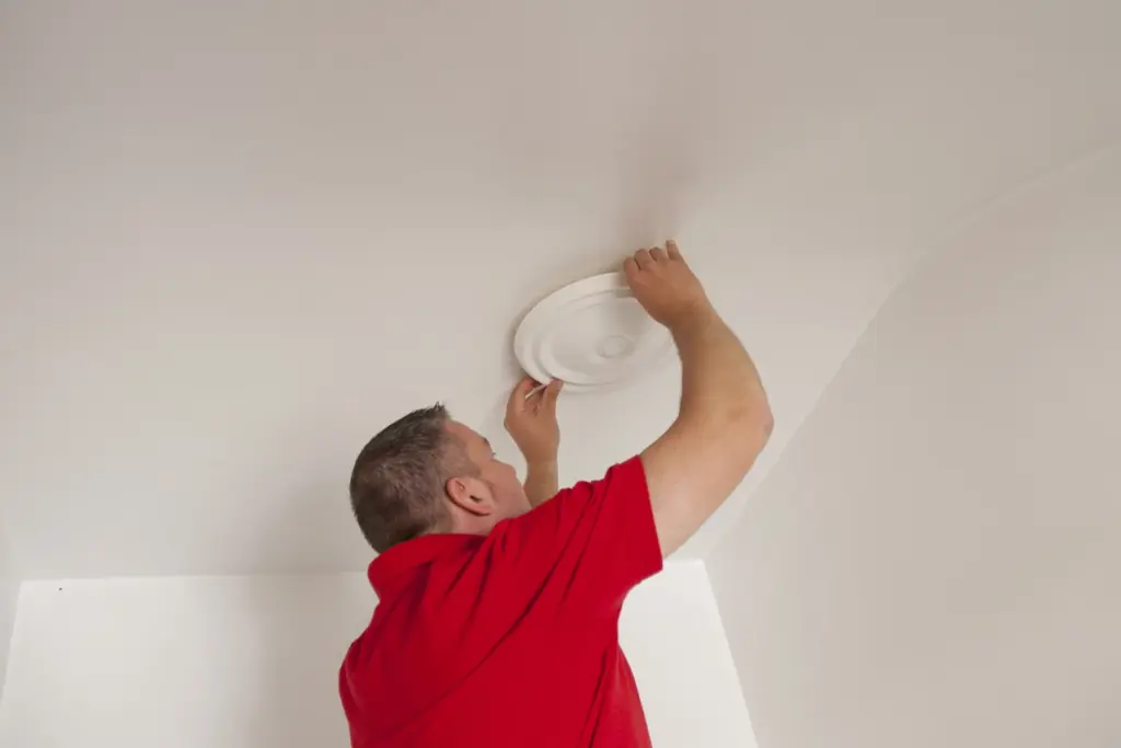 Installer bonding a decorative ceiling rose with Fix All Turbo